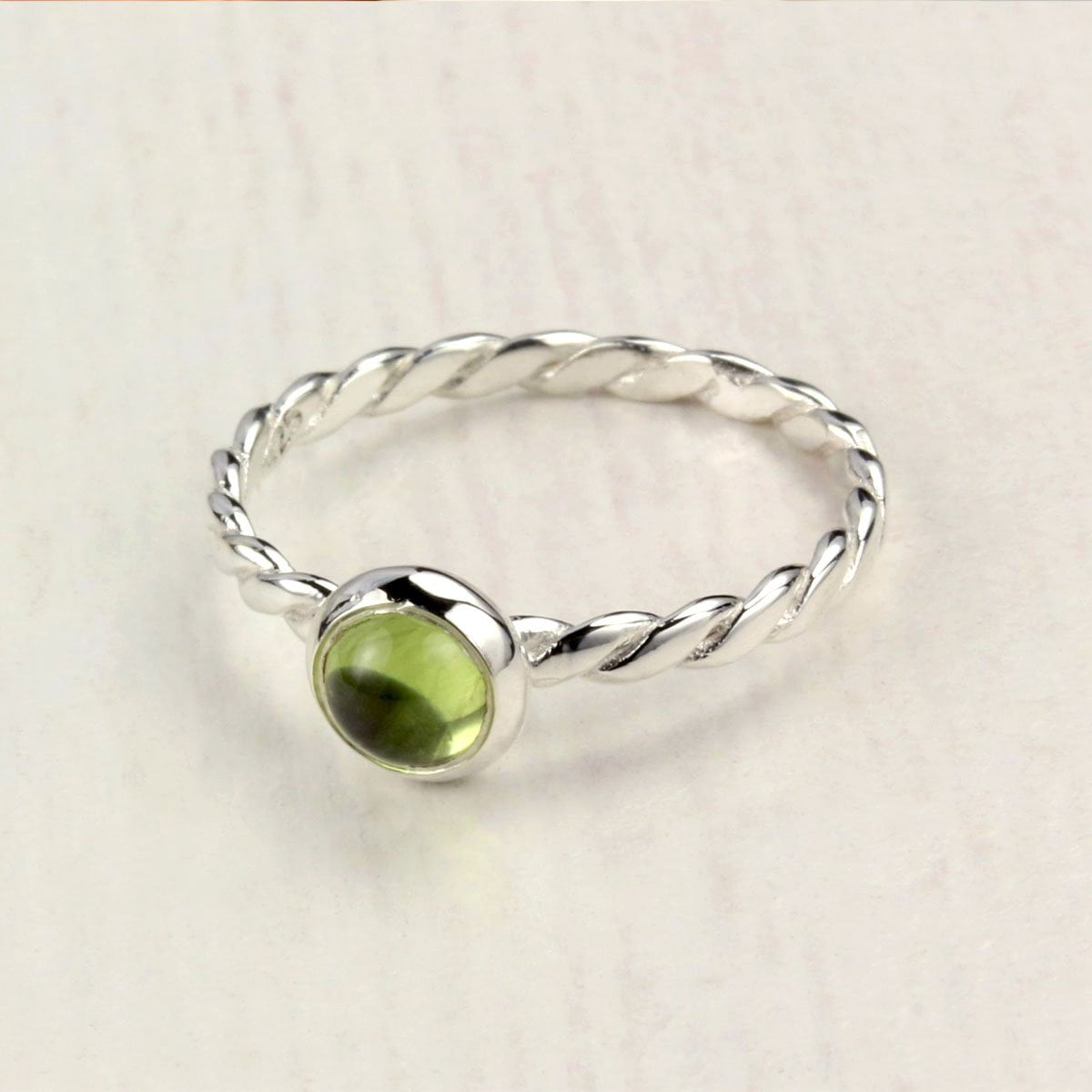 August Birthstone Ring with Peridot in Sterling Silver on table